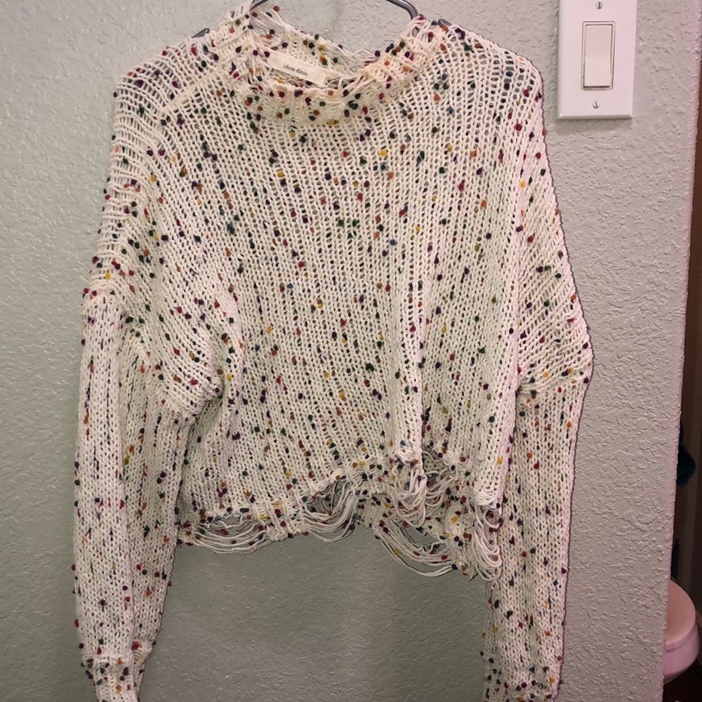 A cute colorful sweater with  a distressed bottom